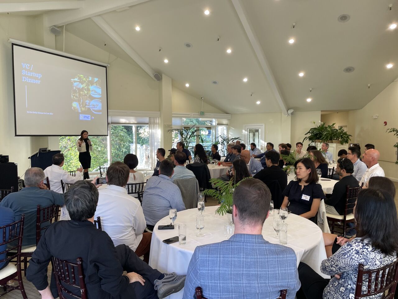 A speaker presenting to Open Future Forum members over dinner
